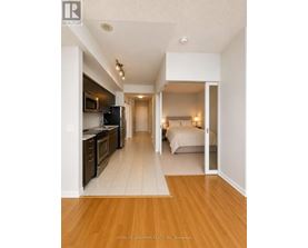 A well lit, spacious apartment with a kitchen and bedroom.