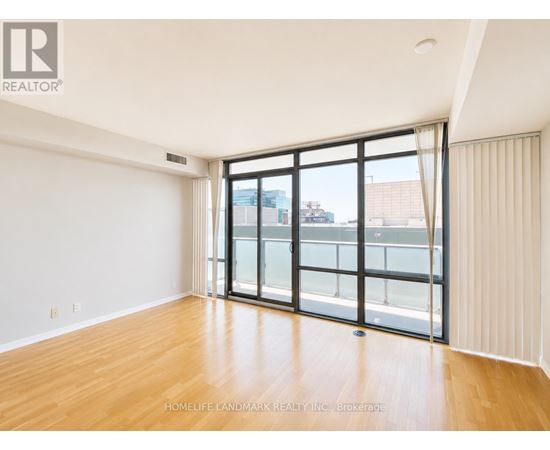A room with a large sliding glass door leading to a balcony.