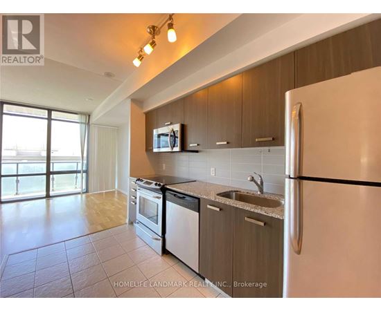 A kitchen with a refrigerator, stove, and microwave.