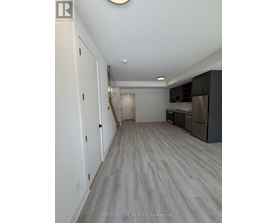 A long hallway with a kitchen area at the end.