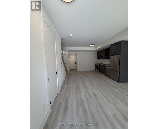 A long hallway with a kitchen area at the end.