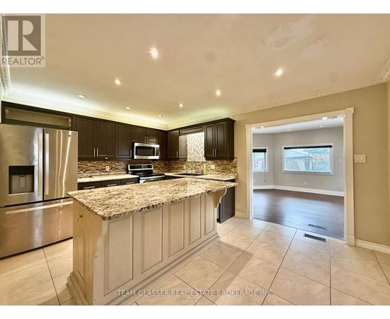 A kitchen with granite countertops and stainless steel appliances.