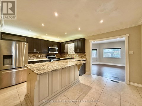 A kitchen with granite countertops and stainless steel appliances.