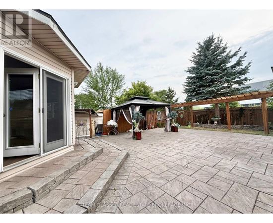 A backyard with a patio and a gazebo.