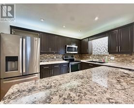 A kitchen with granite countertops and stainless steel appliances.