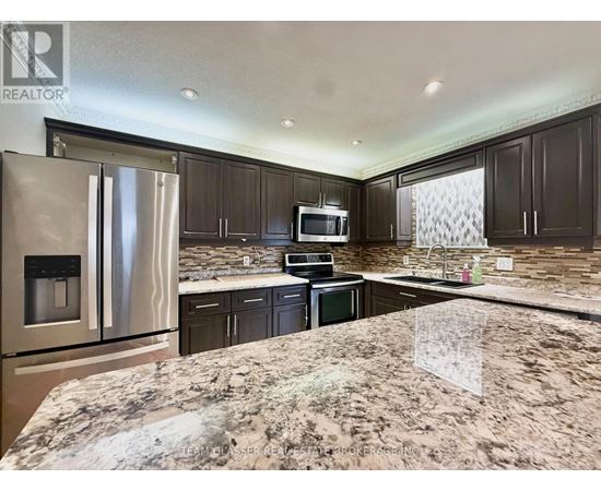A kitchen with granite countertops and stainless steel appliances.