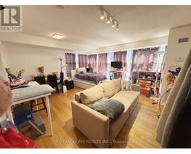 A living room with a couch, a bed, and a television.
