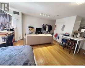 A bedroom with a bed, desk, and closet.