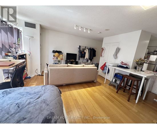 A bedroom with a bed, desk, and closet.