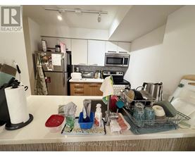 A kitchen counter with various items on it and a refrigerator in the background.