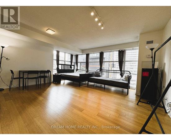 A living room with a black sofa and wooden floors.