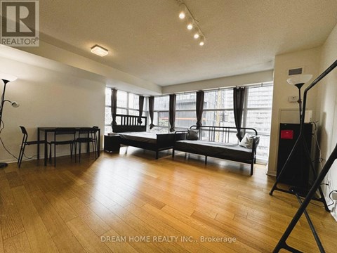 A living room with a black sofa and wooden floors.