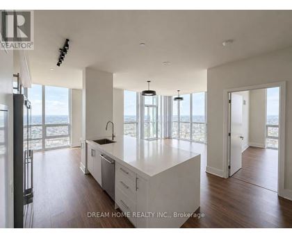 A modern kitchen with a large island and a view of the beach.