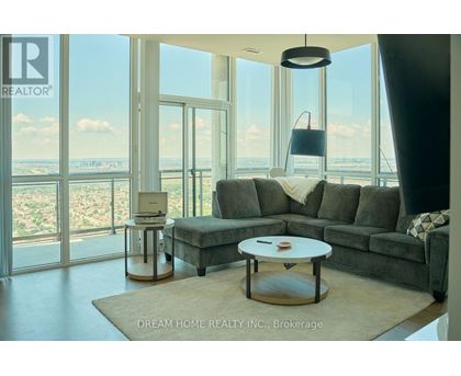 A modern living room with a grey sofa and a coffee table in front of a large window.