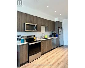 A modern kitchen with wooden cabinets and stainless steel appliances.