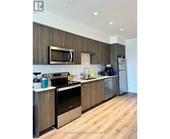 A modern kitchen with wooden cabinets and stainless steel appliances.