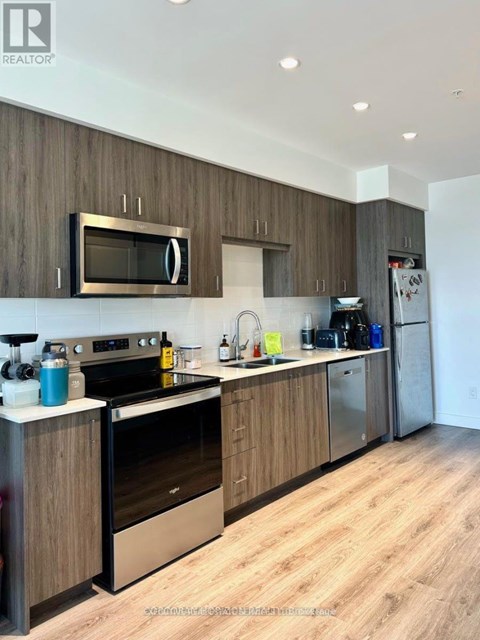 A modern kitchen with wooden cabinets and stainless steel appliances.