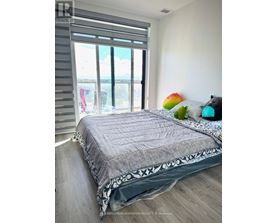 A bedroom with a large bed and a view of the ocean through the window.