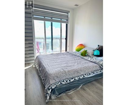 A bedroom with a large bed and a view of the ocean through the window.