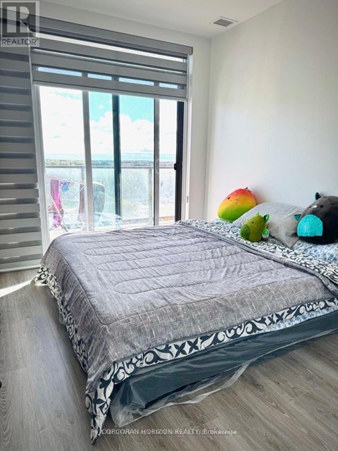 A bedroom with a large bed and a view of the ocean through the window.