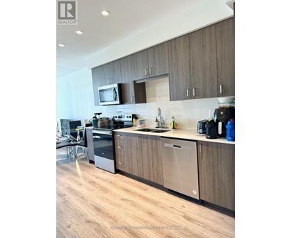 A modern kitchen with wooden cabinets and stainless steel appliances.