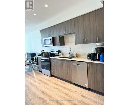A modern kitchen with wooden cabinets and stainless steel appliances.