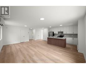 A spacious kitchen with white cabinets and a wooden island.