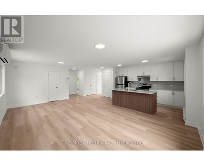 A spacious kitchen with white cabinets and a wooden island.