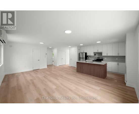 A spacious kitchen with white cabinets and a wooden island.