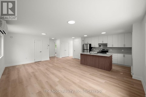 A spacious kitchen with white cabinets and a wooden island.
