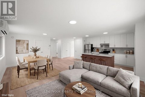 A modern living room with a dining table and a grey sofa.