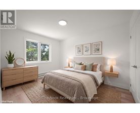 A bedroom with a bed, nightstands, and a plant.