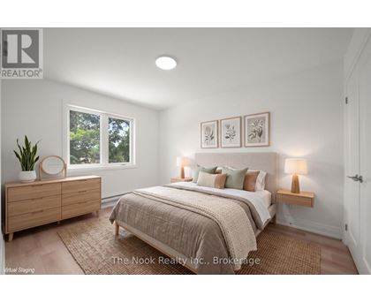 A bedroom with a bed, nightstands, and a plant.