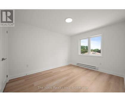 A room with a window that has a view of trees outside.