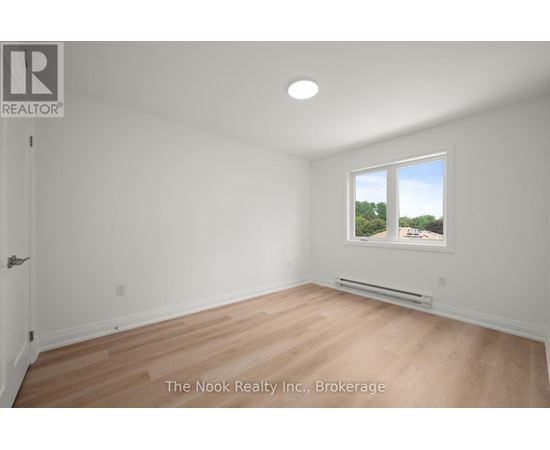 A room with a window that has a view of trees outside.