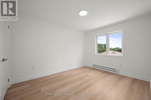 A room with a window that has a view of trees outside.