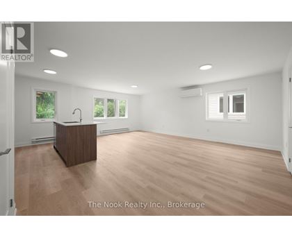 A spacious room with a wooden reception desk and white walls.