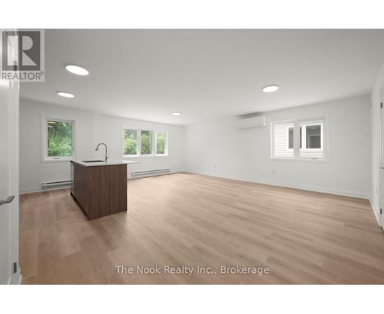A spacious room with a wooden reception desk and white walls.