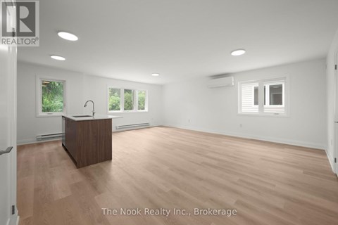 A spacious room with a wooden reception desk and white walls.