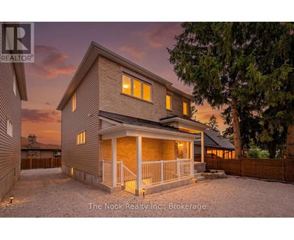 A house with a porch and a fence in front of it.