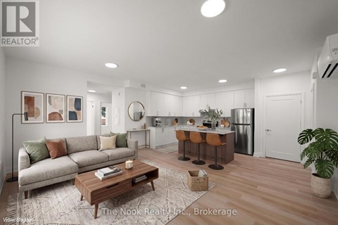 A well-lit, modern living room with a kitchen area in the background.