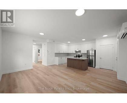 A spacious kitchen with white cabinets and a wooden island.