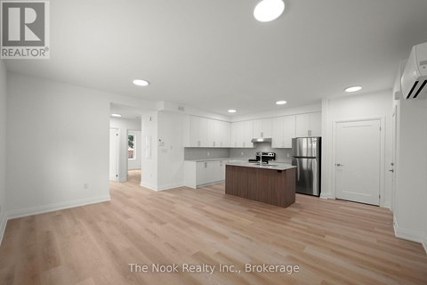 A spacious kitchen with white cabinets and a wooden island.