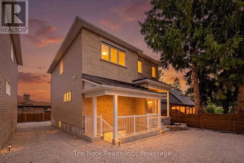 A house with a porch and a fence in front of it.
