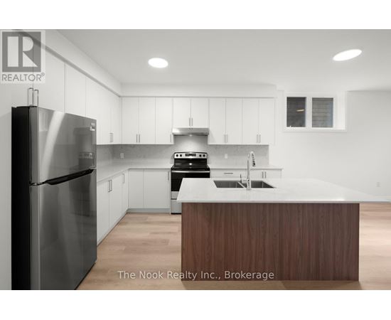 A modern kitchen with a stainless steel refrigerator and wooden island.