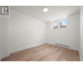 A room with a window showing a building outside.