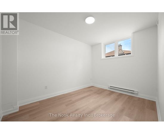 A room with a window showing a building outside.