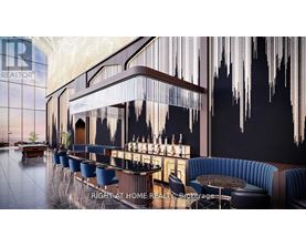 A modern bar with a dark blue booth and a long bar with a blue cushioned bar stool.