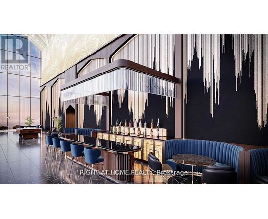 A modern bar with a dark blue booth and a long bar with a blue cushioned bar stool.