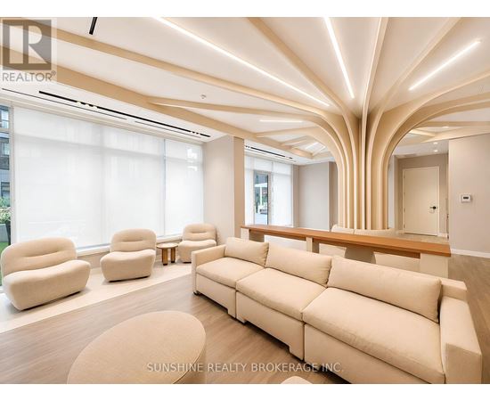 A living room with a large couch and a long table.